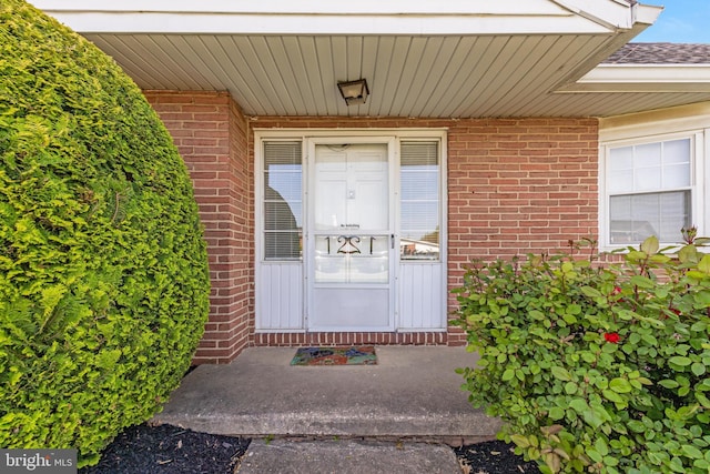 view of exterior entry featuring brick siding