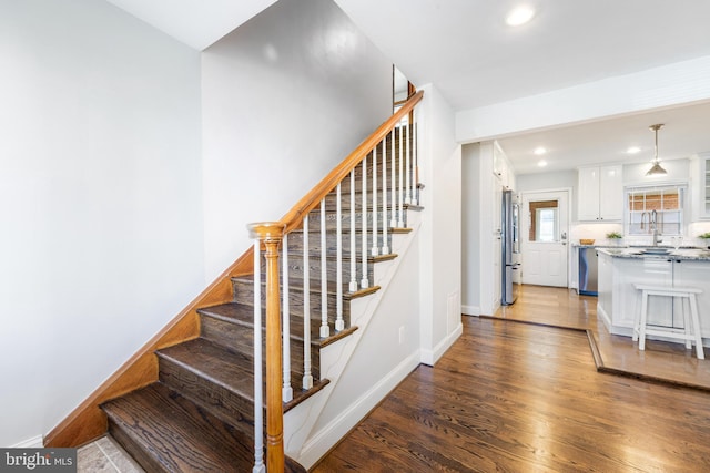 staircase with baseboards, recessed lighting, and wood finished floors