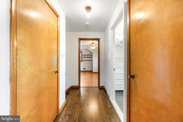 hallway featuring baseboards and wood finished floors