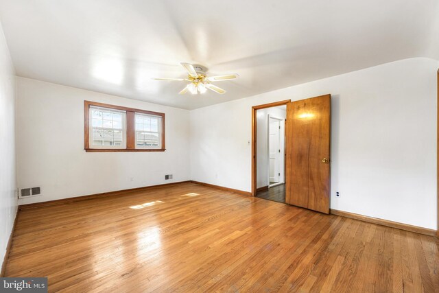 spare room with a ceiling fan, baseboards, visible vents, and light wood-style floors