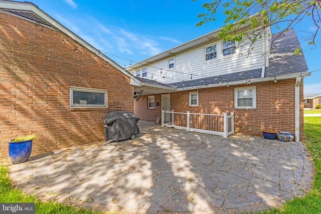 back of house featuring a patio and brick siding