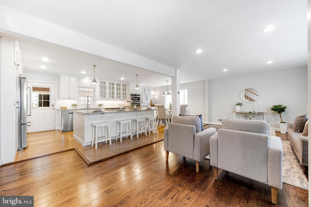 living room featuring recessed lighting, plenty of natural light, and light wood finished floors