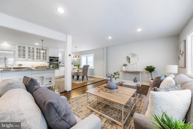 living area with recessed lighting, baseboards, and wood finished floors
