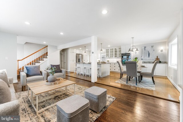 living area featuring recessed lighting, light wood-style flooring, and stairway