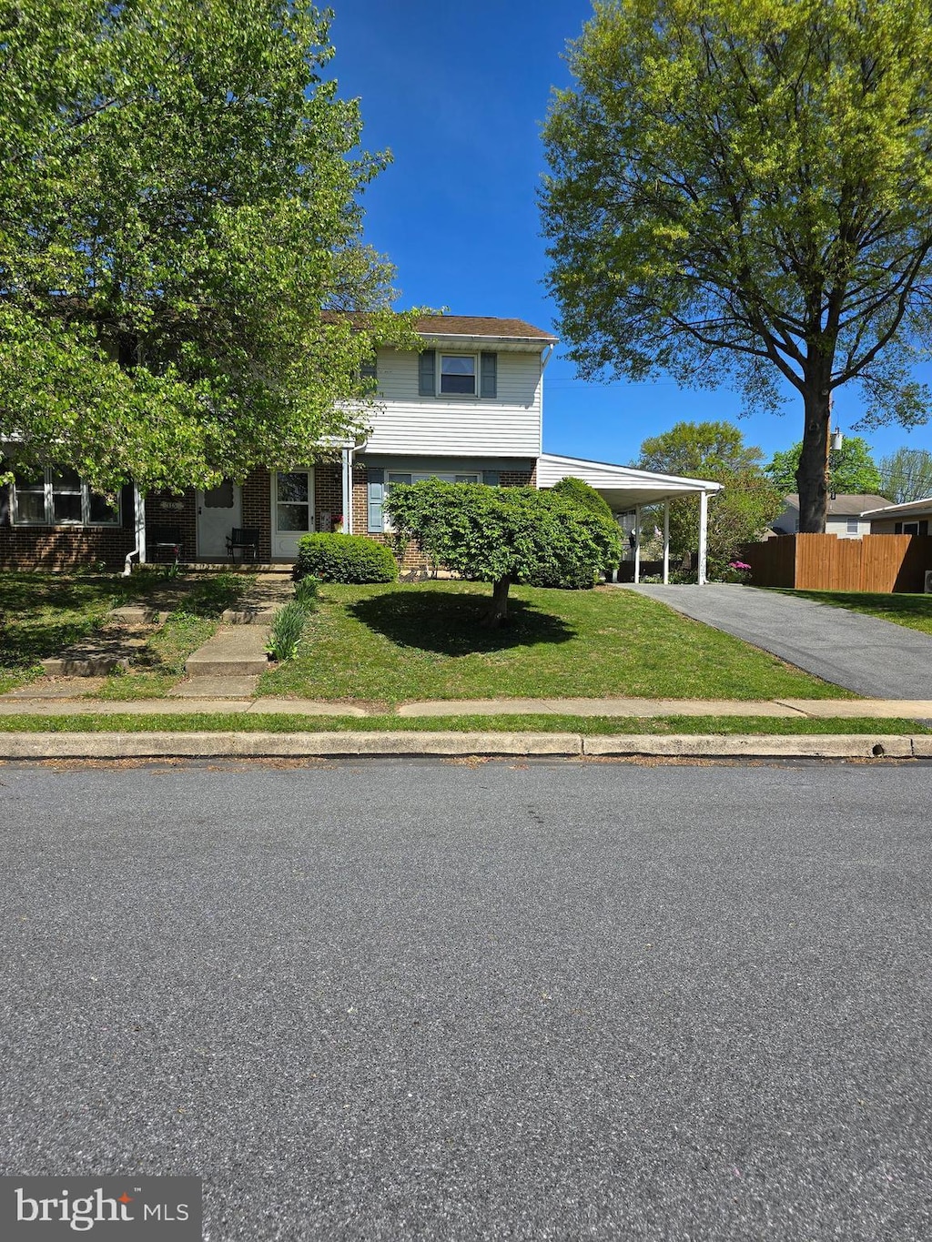 view of front of home featuring fence, a front lawn, a carport, and aphalt driveway