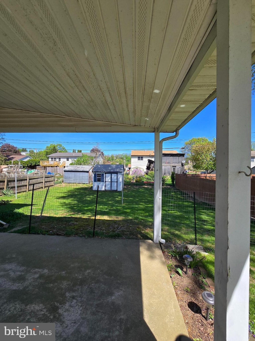 view of yard featuring fence, an outbuilding, and a patio area