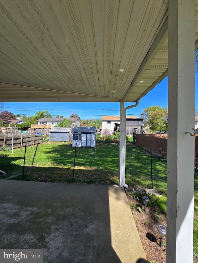 view of yard featuring fence, an outbuilding, and a patio area