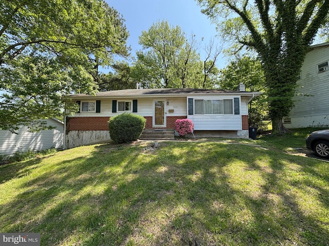 ranch-style home with brick siding, a chimney, and a front yard