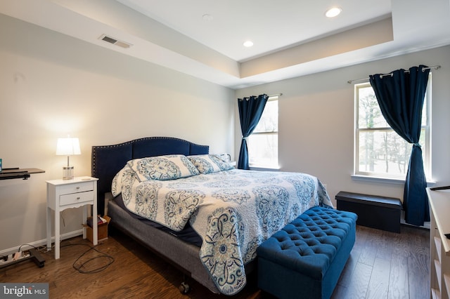 bedroom featuring visible vents, wood finished floors, and multiple windows