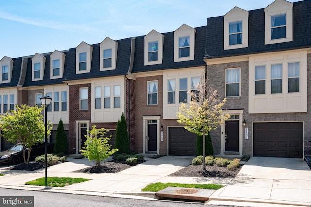 multi unit property with brick siding, an attached garage, driveway, and a shingled roof