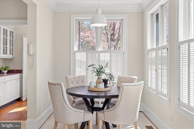 dining area with crown molding, baseboards, and light tile patterned floors