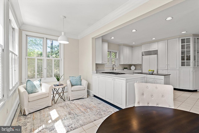 kitchen with white cabinets, paneled built in fridge, light tile patterned floors, ornamental molding, and glass insert cabinets