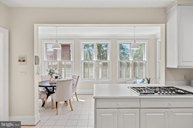 kitchen featuring white cabinets, baseboards, a healthy amount of sunlight, and stainless steel gas stovetop