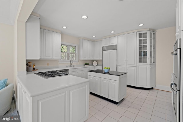 kitchen featuring appliances with stainless steel finishes, a peninsula, white cabinetry, recessed lighting, and glass insert cabinets