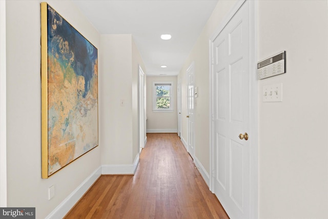 hall featuring recessed lighting, baseboards, and wood finished floors