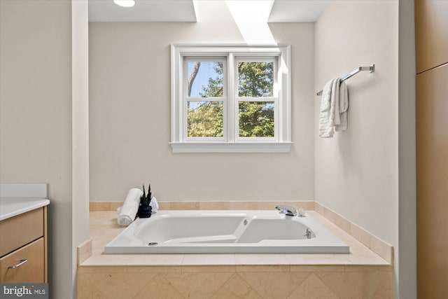 bathroom featuring a garden tub and vanity