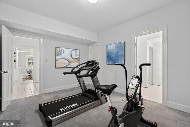 exercise room featuring baseboards, tile patterned flooring, and carpet flooring
