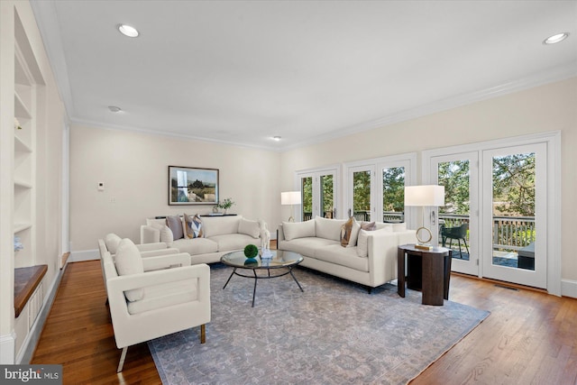 living area with crown molding, wood finished floors, and a wealth of natural light