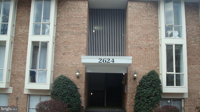 entrance to property featuring brick siding