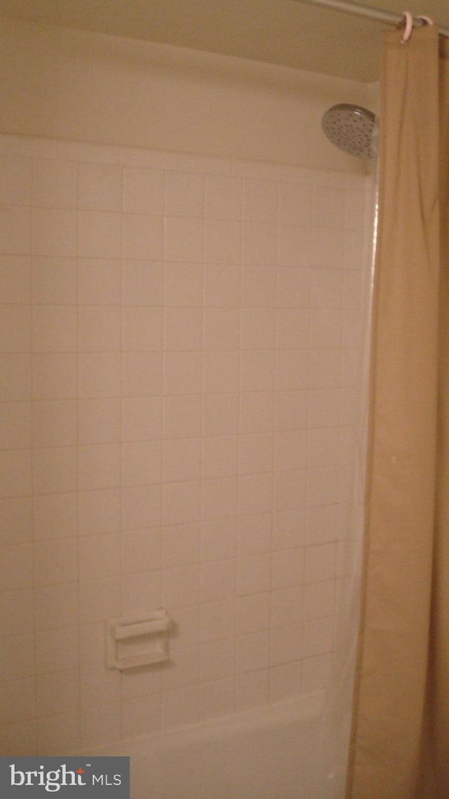interior details featuring a shower with shower curtain