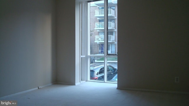carpeted spare room featuring baseboards