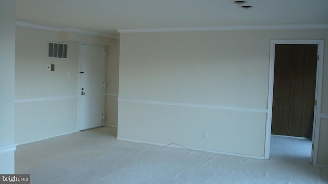 carpeted spare room with visible vents and ornamental molding