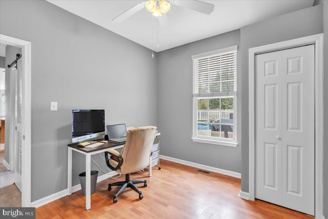 home office with baseboards, a ceiling fan, wood finished floors, and visible vents