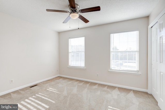 unfurnished bedroom featuring baseboards, carpet, a closet, and visible vents
