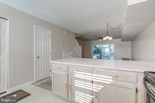 kitchen featuring visible vents, light countertops, a textured ceiling, baseboards, and stainless steel electric stove