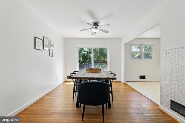 dining room with a ceiling fan, wood finished floors, and baseboards