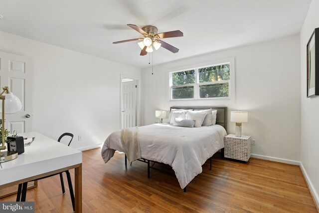 bedroom with wood finished floors, baseboards, and a ceiling fan