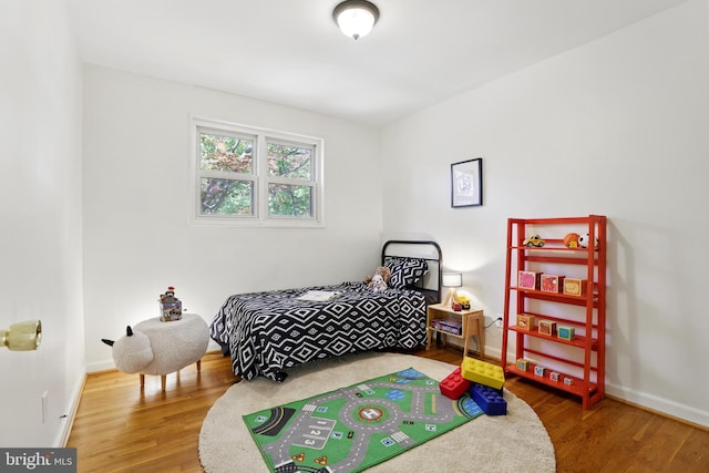 bedroom featuring wood finished floors and baseboards
