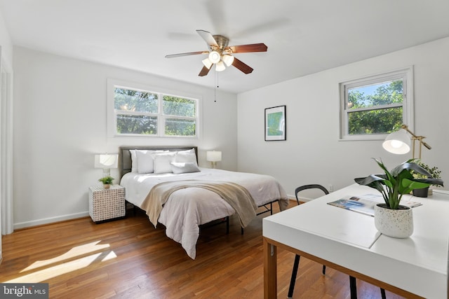 bedroom with wood finished floors, baseboards, and ceiling fan