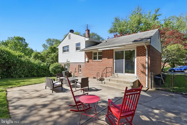 rear view of house with brick siding, a chimney, fence, and central AC unit
