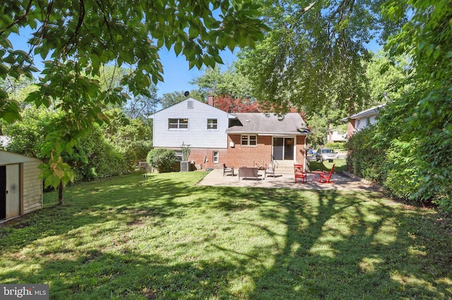 rear view of property with brick siding, a patio, entry steps, a storage shed, and a lawn