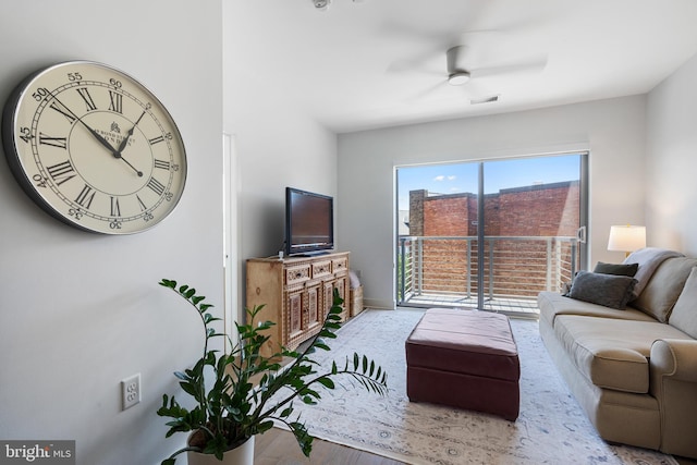 living room featuring visible vents, baseboards, ceiling fan, and wood finished floors