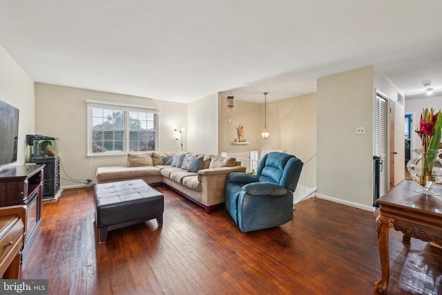 living room featuring dark wood-type flooring and baseboards