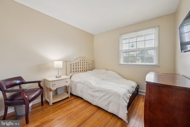bedroom featuring light wood finished floors and baseboards