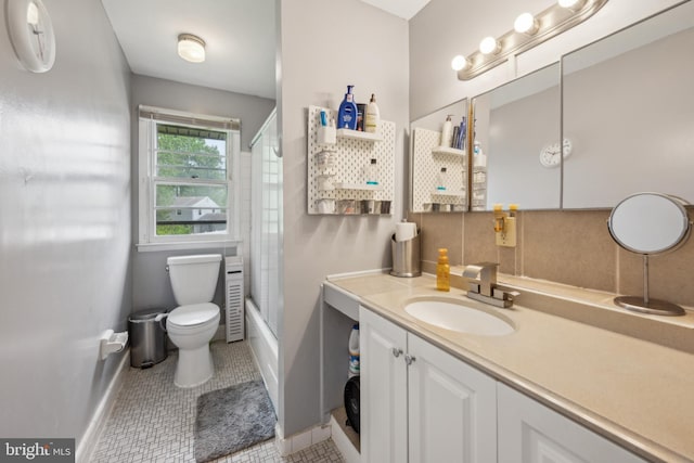 full bath featuring baseboards, toilet, vanity, enclosed tub / shower combo, and tile patterned floors
