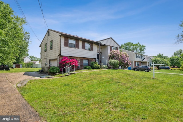 view of front of property with asphalt driveway, a garage, and a front yard
