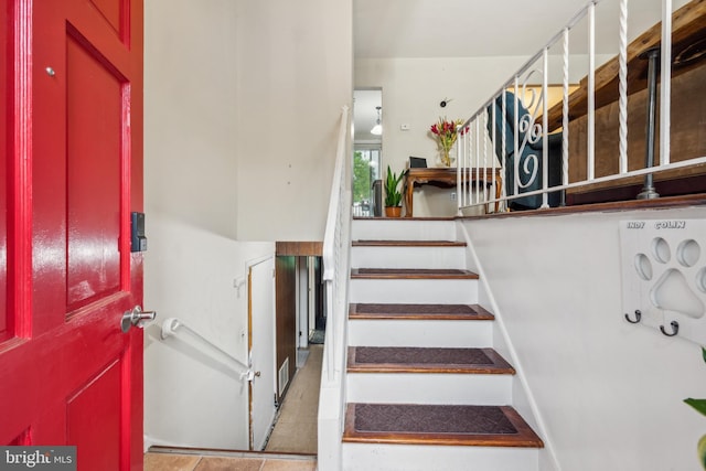 stairway featuring tile patterned flooring