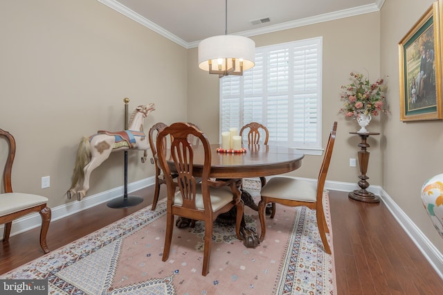 dining room featuring crown molding, baseboards, wood finished floors, and visible vents