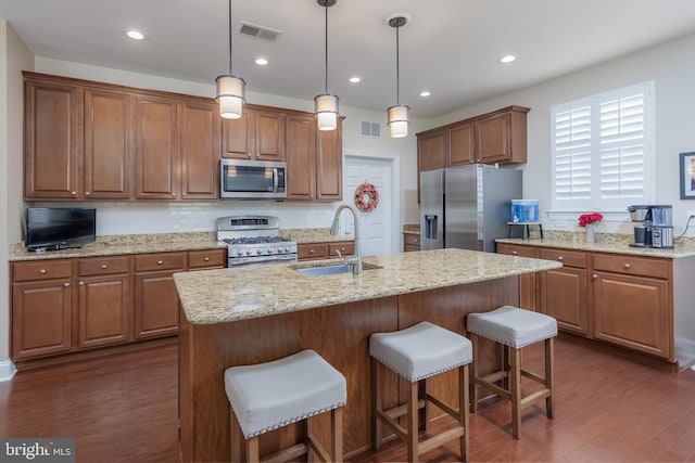 kitchen featuring visible vents, a sink, dark wood-style floors, and stainless steel appliances