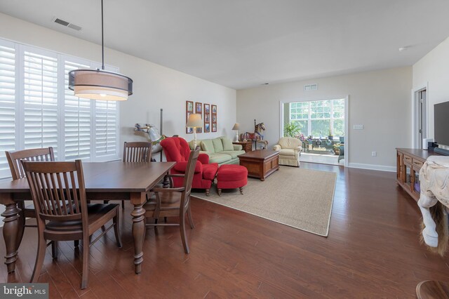 dining area with baseboards, visible vents, and wood finished floors