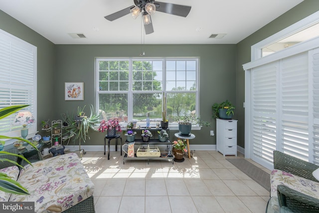 living area with visible vents, a ceiling fan, baseboards, and tile patterned flooring