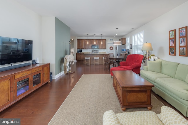 living room with recessed lighting, baseboards, and dark wood finished floors
