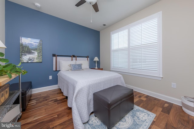 bedroom with baseboards, wood finished floors, and visible vents