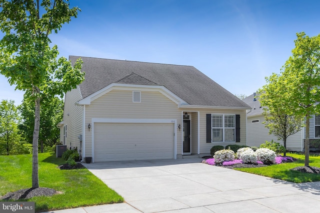view of front of property featuring driveway, a front yard, central AC, an attached garage, and a shingled roof