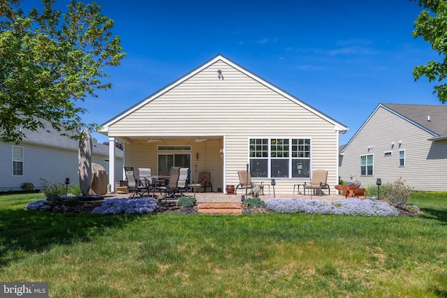 rear view of property featuring a patio and a yard