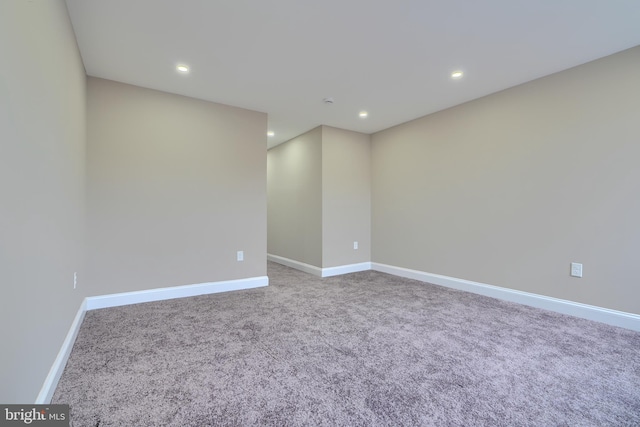 carpeted spare room featuring baseboards and recessed lighting